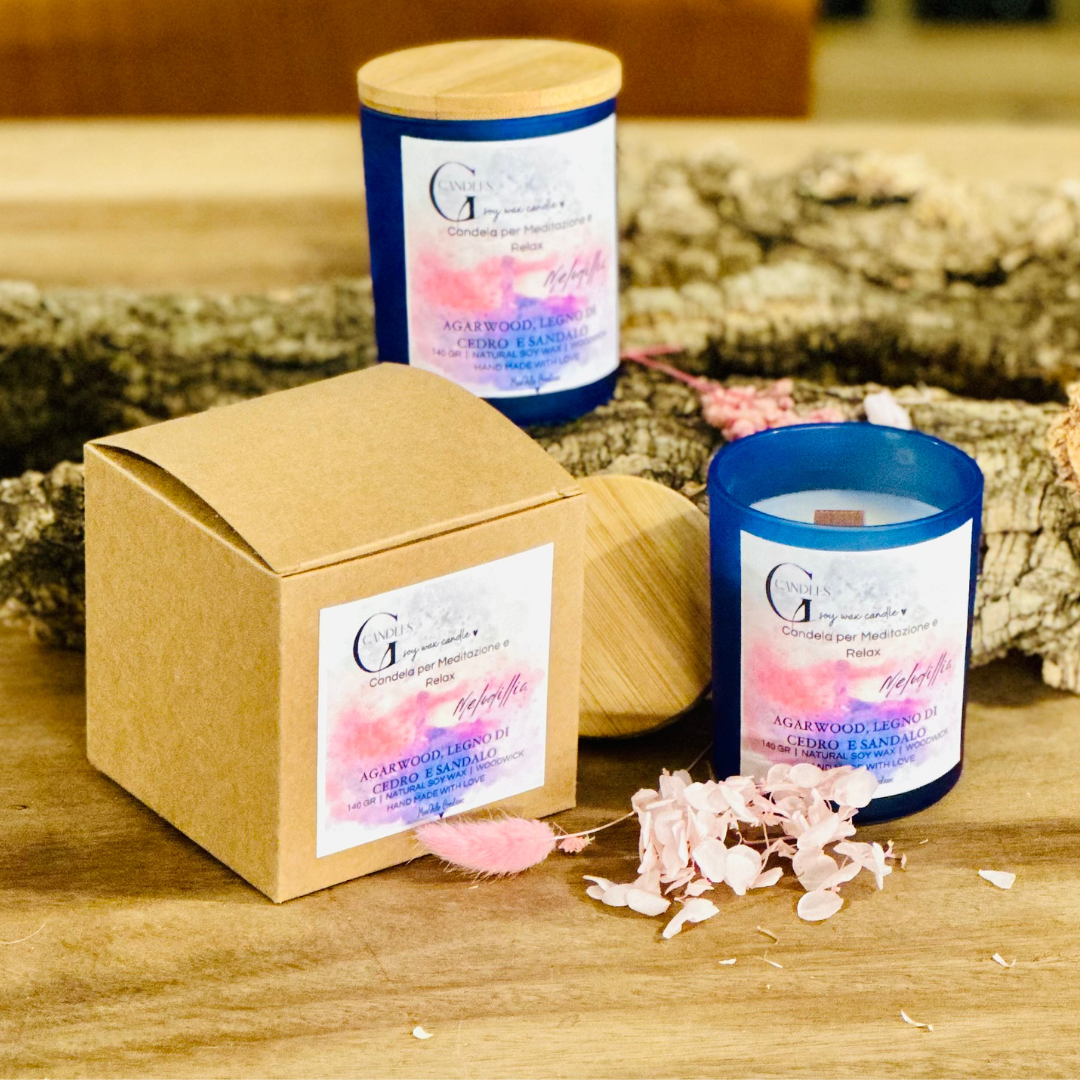 Vasetto blu in vetro con coperchio in bambu' per candela da meditazione alla cera di soia artigianale profumata al legno di sandalo e legno di cedro, la grafica è realizzata su sfondo viola, blu e rosa.