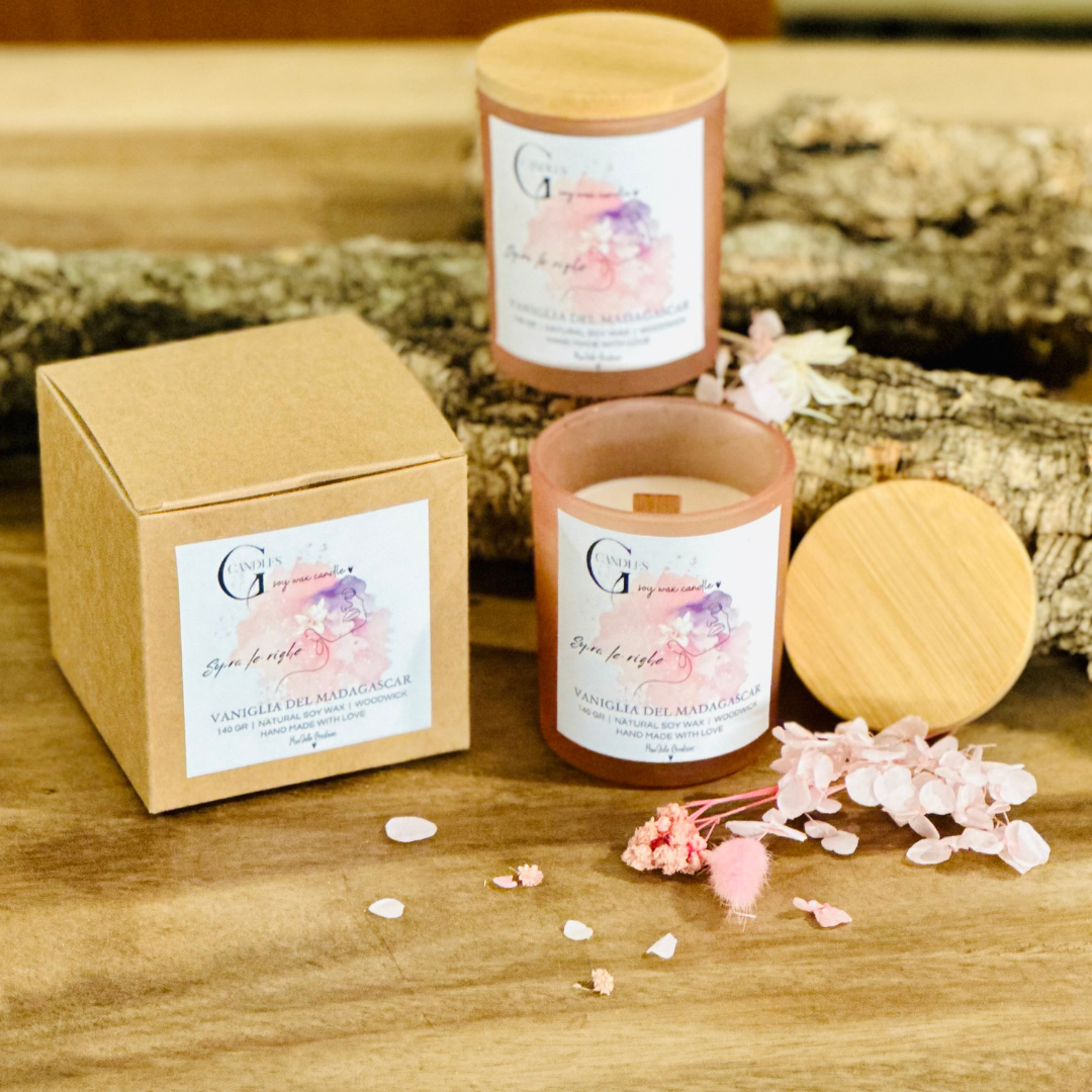 Vasetto rosa chiaro in vetro con coperchio in bambu' per candela alla cera di soia artigianale profumata alla vaniglia del Madagascar, la grafica realizzata a mano rappresenta un volto di donna stilizzato su sfondo viola e rosa.