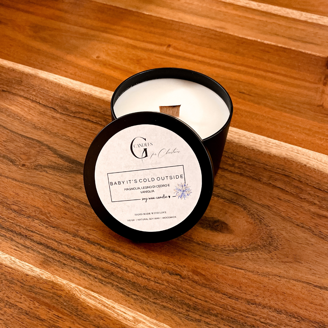 Candela in cera di soia naturale con un delicato aroma natalizio realizata artigianalmente dentro un barattolino nero in alluminio con coperchio. Lo stoppino è in legno di pioppo e la grafica con logo dell'etichetta sul coperchio ne indica la fragranza.