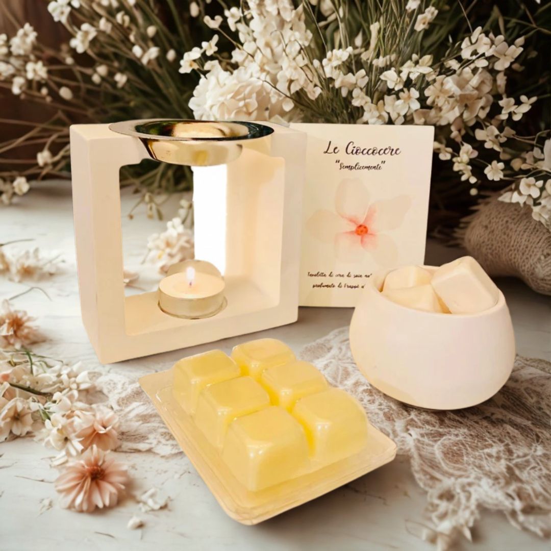 Bruciatore in ceramica bianca con vaschetta di cera da sciogliere alla vaniglia, barattolino, fiori decorativi e cartoncino illustrato.