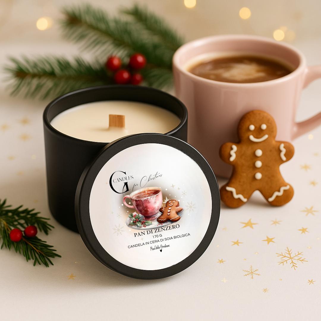 Candela profumata al gusto di pan di zenzero in cera di soia biologica colata a mano in barattolo di alluminio nero con stoppino in legno, decorata con illustrazioni di tazza rosa con liquido marrone e biscotto a forma di omino di pan di zenzeroo, su sfondo con colori chiari, caldi, elelmenti naturali e lucine natalizie.