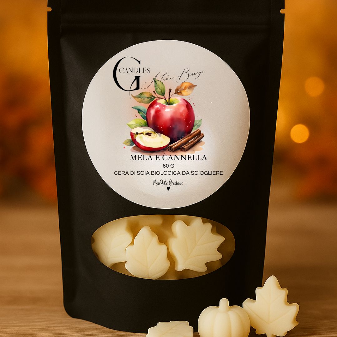 Wax melts al profumo di mela e cannella, in cera di soia biologica, artigianale in bustina nera con finestra trasparente, sfondo ambrato, con piccole cere a forma di foglia e di zucca decorative.
