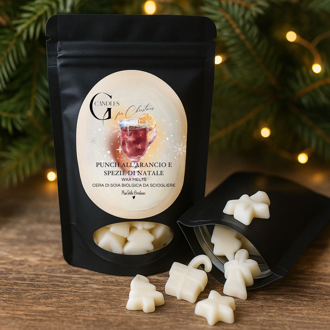 Wax melts natalizie al profumo di punch all'arancio, artigianali in cera di soia biologica a forma di alberelli e pacchi regalo e stelline, in bustina nera con finestra, con sfondo di abete e lucine su un piano in legno rustico.