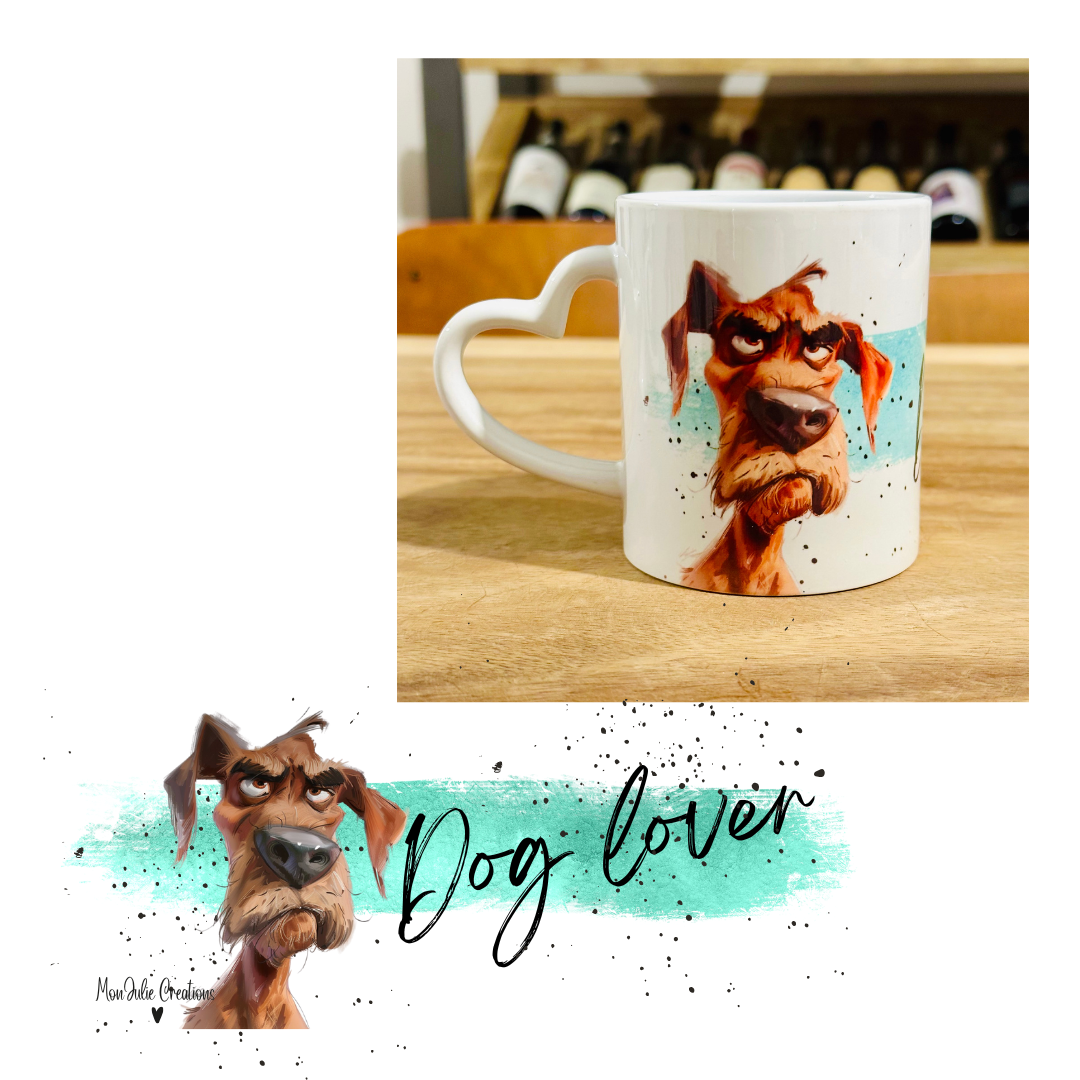 Tazza mug da 325 ml in ceramica con manico a forma di cuore per gli amanti dei cani, con uma grafica che raffigura un cane di colore marrone su sfondo azzurro con puntini neri con la scritta Dog lover,  dall'aria imbronciata ma estremamente simpatica.  L'immagine sottostante rappreseta per intero la grafica con stampa sublimatica. Grafiche divertenti e originali realizzate a mano.