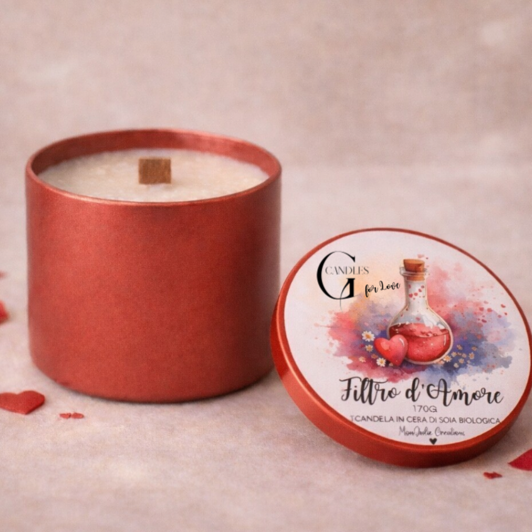 Candela in cera di soia bianca al profuma per San Valentino "Filtro d' Amore" con stoppino in legno in barattolino rosso. Grafica artigianale su coperchio. Piano in legno chiaro e petali rossi come dettagli decorativi.