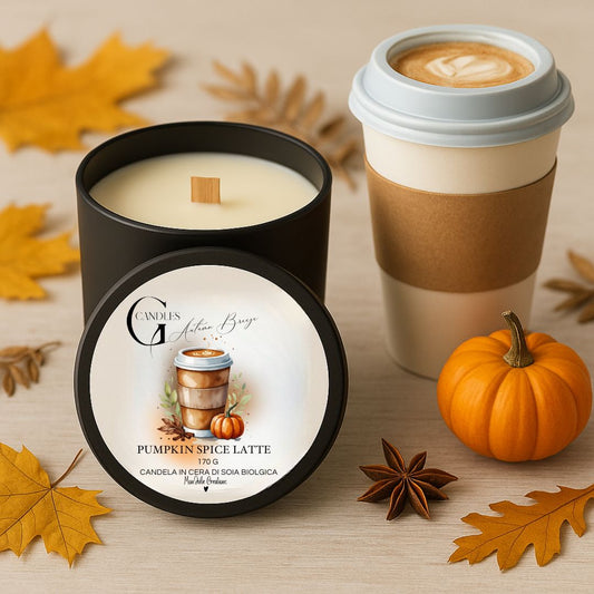Candela al profumo di pumpkin spice latte in cera di soia biologica in barattolo nero, con zucca decorativa, bicchiere per caffè da asporto e decorazioni autunnali.