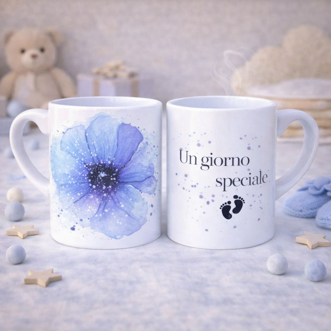 Tazza mug in ceramica bianca fronte e retro con fiore grande blu e scritta con piedini, su piano bianco con stelline e dettagli decorativi da bebè color crema e azzurro, con orsetto sullo sfondo.