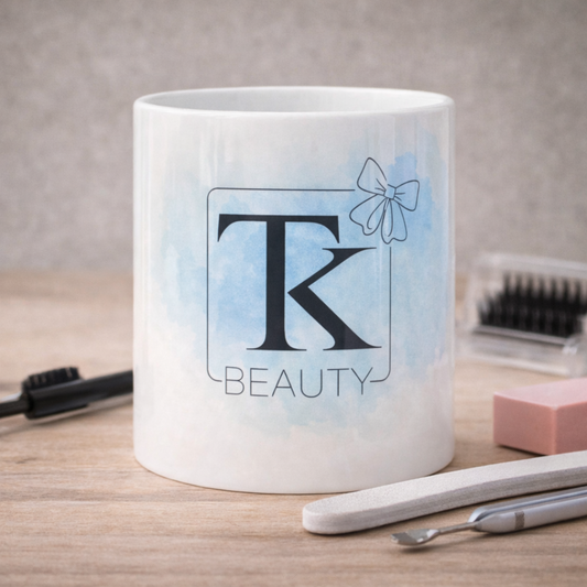 Tazza mug in ceramica bianca con logo aziendale personalizzato per centro estetico, su sfondo chiaro in legno con oggetti per cura delle unghie e delle ciglia.