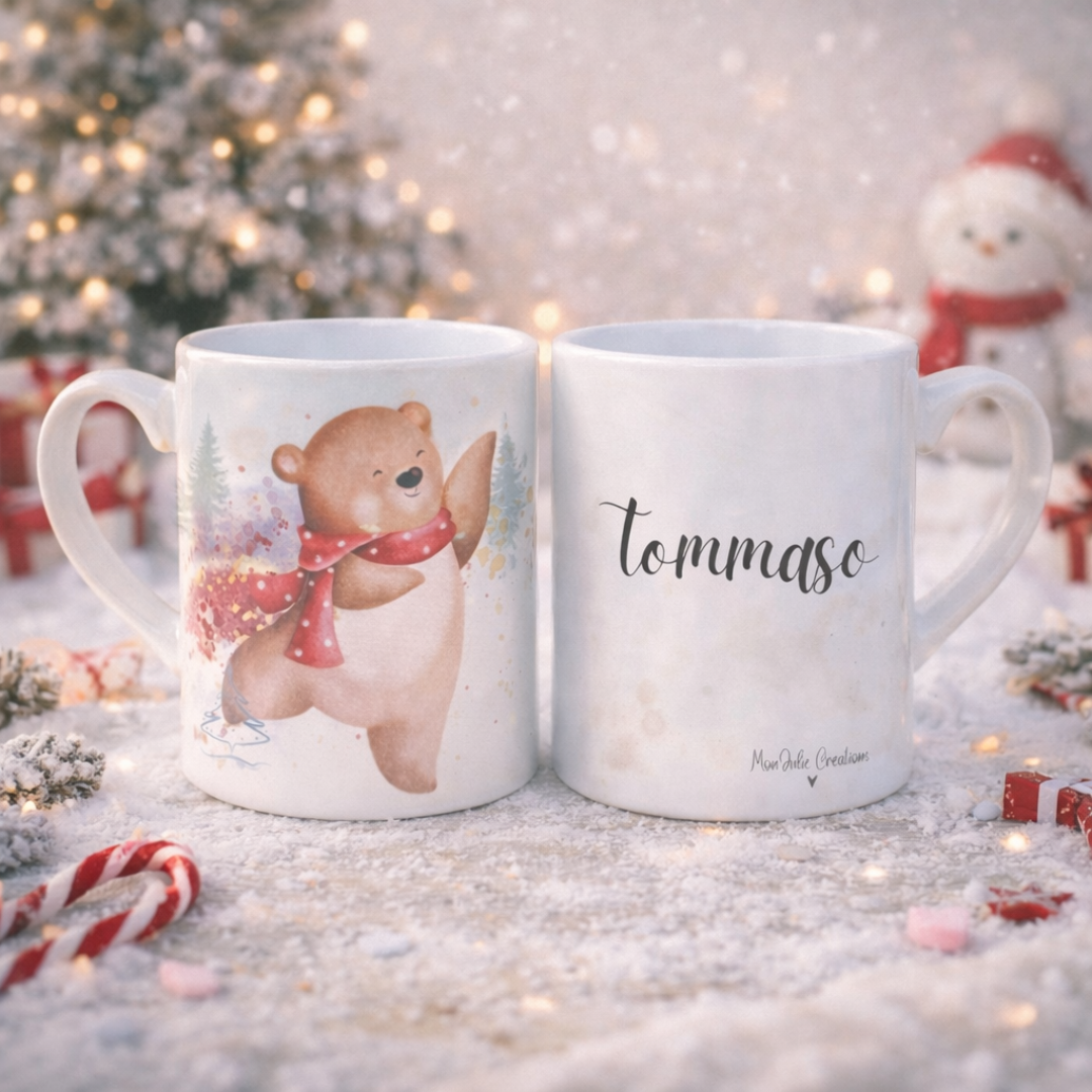 Tazza mug in ceramica bianca natalizia per bambini, con nome prsonalizzato e grafica con orsetto e sciarpina rossa, su piano innevato, con stecco di zucchero, dettagli decorativi bianchi e rossi e papazzetto di neve giocattolo.