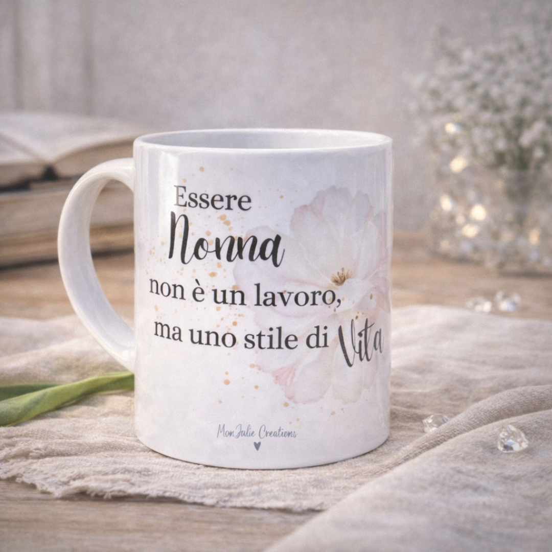 Tazza in ceramica bianca con dedica per la nonna con fiore grande bianco, su piano in legno chiaro, su tessuto in lino naturale e dettagli decorativi.
